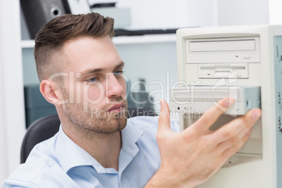Computer engineer inserting cd/dvd player into computer case