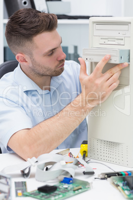 Computer engineer inserting cd/dvd player into computer case