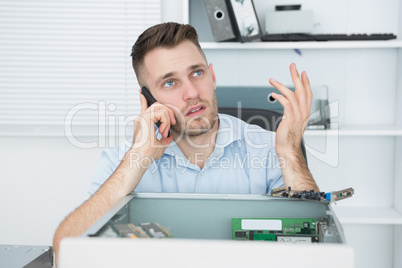 Worried computer engineer on call in front of open cpu