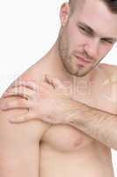 Close-up of shirtless man with shoulder pain