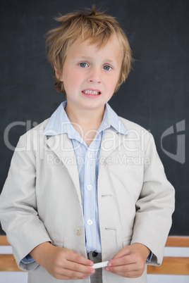 Boy dressed as teacher in front of black board