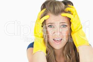 Young upset chore woman wearing yellow cleaning gloves