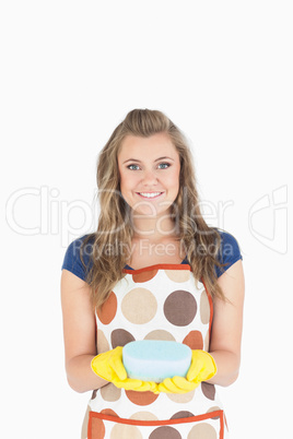 Portrait of smiling young maid holding sponge