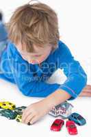 Close-up of boy playing with playhouse and toy cars