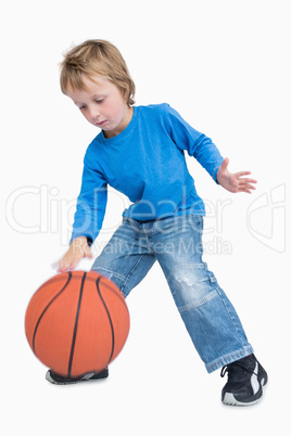 Young casual boy playing basketball