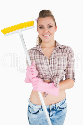 Portrait of casual young woman holding broom