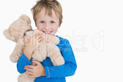Portrait of happy young boy hugging teddy bear