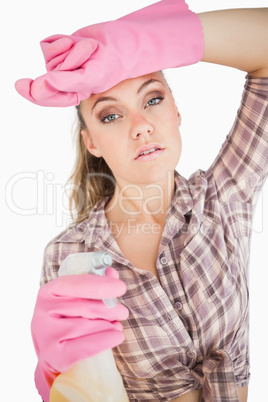 Portrait of tired young woman holding spray bottle