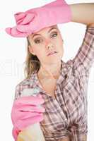 Portrait of tired young woman holding spray bottle