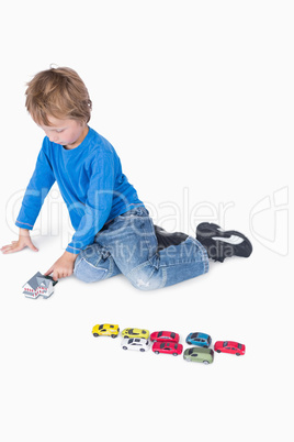 Young boy playing with playhouse and toy cars