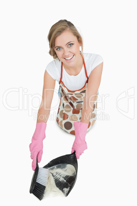 Portrait of smiling maid using brush and dust pan