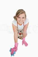 Young maid cleaning floor over white background