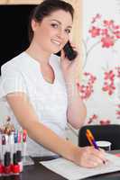 Woman answering phone at reception of nail salon