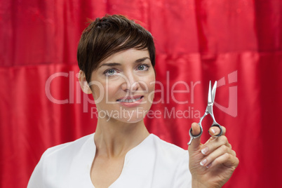 Portrait of confident female hairdresser with hair scissors