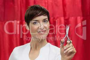 Portrait of confident female hairdresser with hair scissors