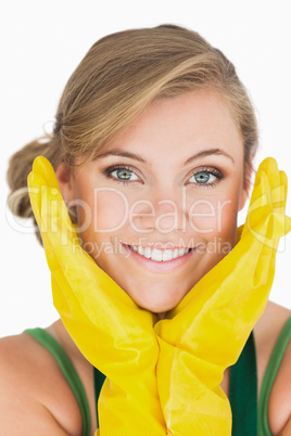 Close-up of smiling young maid with yellow gloves