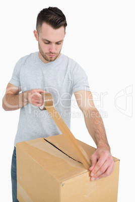 Man sealing cardboard box with packing tape