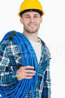Portrait of smiling young male architect carrying coiled blue tu