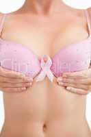 Woman with breast cancer awareness ribbon attached to bra