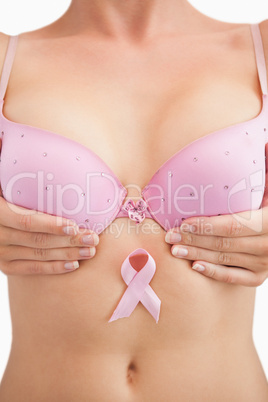 Woman in bra with breast cancer awareness ribbon