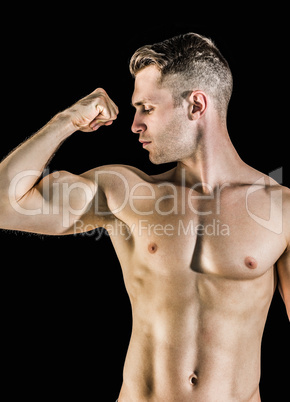 Shirtless young man flexing muscles