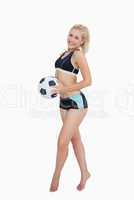 Portrait of happy woman in sportswear holding football