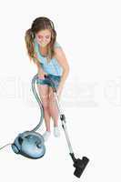 Woman listening music over headphones while vacuuming
