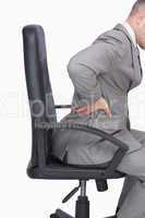 Business man with backache sitting in an office chair
