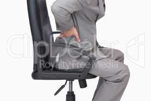 Business man with backache sitting in an office chair