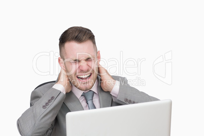 Business man suffering from severe neck pain while using laptop
