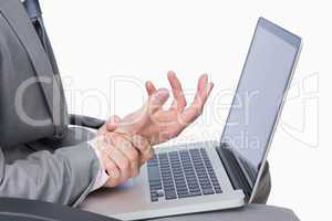 Business man with wrist pain while using laptop