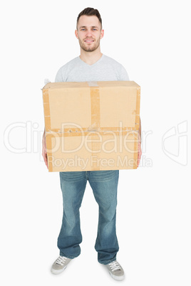 Portrait of young man carrying cardboard box