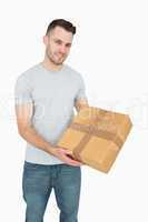 Portrait of young man carrying cardboard box