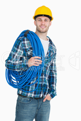 Portrait of smiling male architect carrying coiled blue tubing