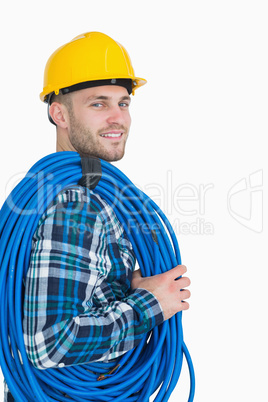 Portrait of smiling young male architect carrying coiled blue tu