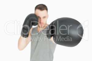 Portrait of young male boxer punching