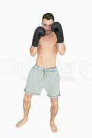 Portrait of shirtless young boxer in shorts