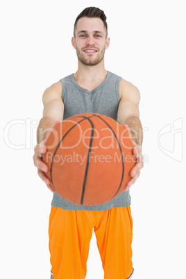 Portrait of happy young man holding basketball