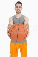 Portrait of happy young man holding basketball