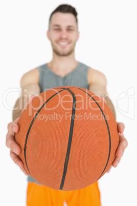 Portrait of happy young man holding basketball