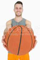 Portrait of happy young man holding basketball