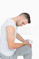 Side view of young man exercising with dumbbell