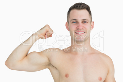 Portrait of shirtless young man flexing muscles