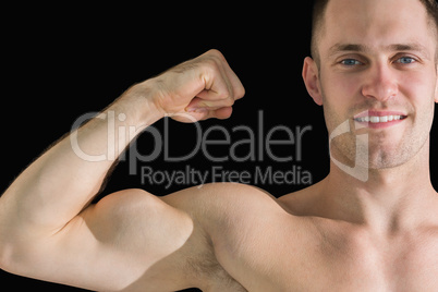 Close-up portrait of young man flexing muscles