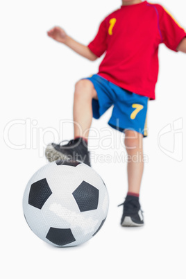 Young boy with foot on soccer ball