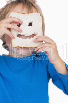 Boy looking through holes in bread slice