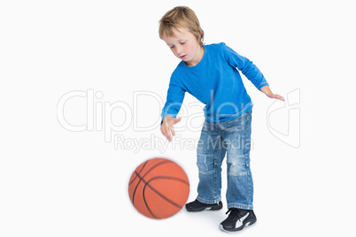 Young casual boy playing basketball