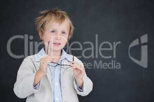 Boy dressed as teacher in front of black board