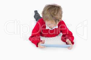 Little boy lying on floor and using digital tablet