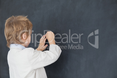 Boy dressed as teacher and writes on black board